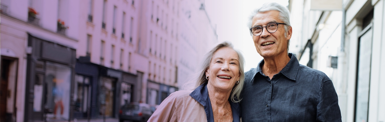 elderly couple walking through city and smiling