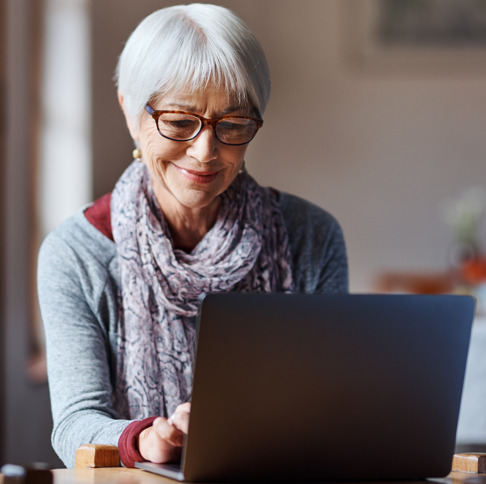 an elderly woman enrolls in Medicare on her laptop