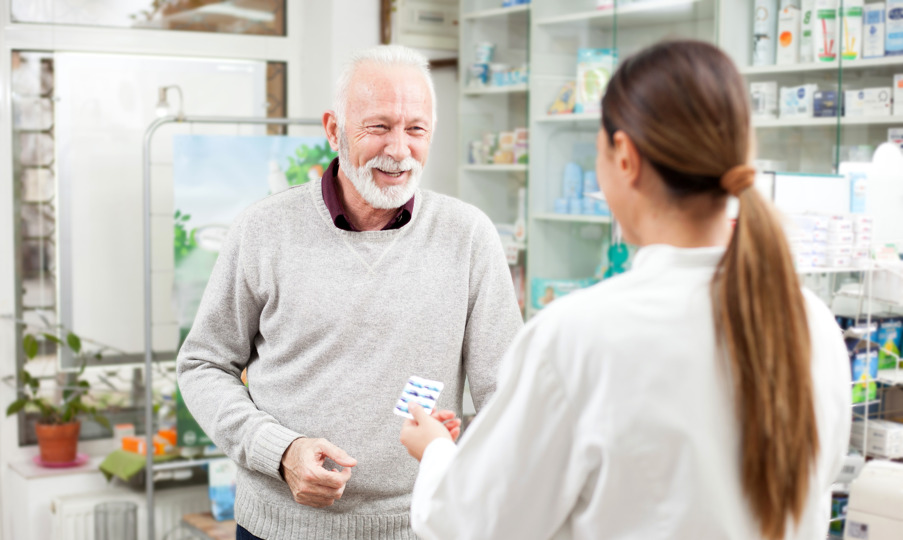 an elderly man visits pharmacy and picks up medications